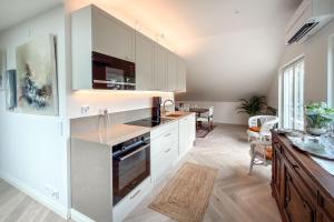 a kitchen with white cabinets and a counter top at Villa Maija 6 Topside in Hanko