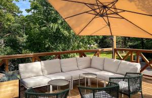 a white couch sitting under an umbrella on a deck at Villa Maija 6 Topside in Hanko +17 photos