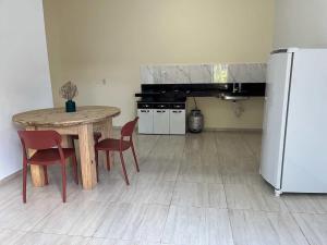 a kitchen with a wooden table and a refrigerator at Vila da Andrea in Barreirinhas +1 photo