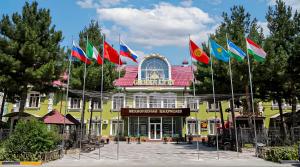 a group of flags in front of a building at Green City Hotel ШАХРИСАБЗ in Khujand