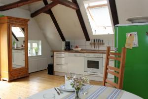 a kitchen with a table and a green refrigerator at Altes Rauchhaus in Ebstorf