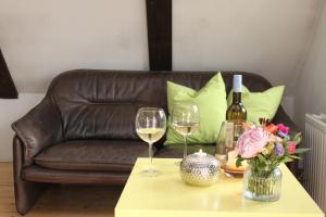 a couch with two glasses of wine and a table with flowers at Altes Rauchhaus in Ebstorf