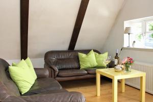 a living room with a leather couch and a table at Altes Rauchhaus in Ebstorf