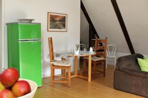 a kitchen with a green refrigerator and a table and chairs at Altes Rauchhaus in Ebstorf +18 photos