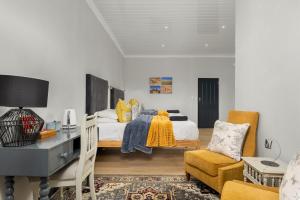 a bedroom with a bed and a desk and chair at Ukholo Lodge in Citrusdal