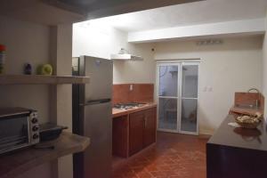 a kitchen with a stainless steel refrigerator and a microwave at Departamento Loro in Manzanillo