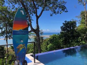 a surfboard sitting next to a swimming pool at Club Fred in Ojochal