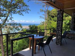 a balcony with a table and chairs and the ocean at Club Fred in Ojochal