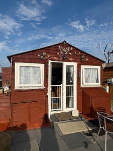 a small red house with two windows and a door at The Butterfly in Leysdown-on-Sea