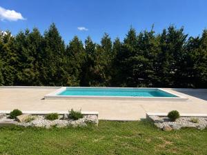 a swimming pool in a yard with trees at Pine House - Holiday Home in Banja Luka