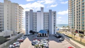 a parking lot with cars parked in front of buildings at Romar Tower 6B in Orange Beach