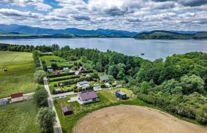 an aerial view of a farm next to a lake at Ubytovanie v objatí Liptova in Žiar