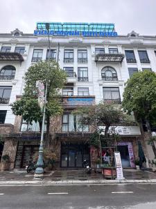 a white building with a sign on top of it at Vững Mạnh Hotel in Ðồng Ky