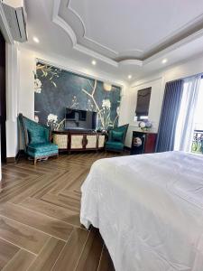 a bedroom with a bed and two chairs and a television at Vững Mạnh Hotel in Ðồng Ky
