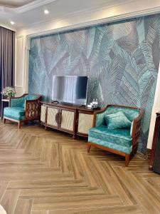 a living room with two chairs and a flat screen tv at Vững Mạnh Hotel in Ðồng Ky