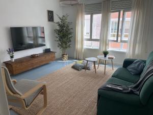ein Wohnzimmer mit Sofa und Fernseher in der Unterkunft Amancay in Cedeira