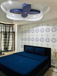 a bedroom with a blue bed and a ceiling at Villa Grand Classic in Covelong +25 photos