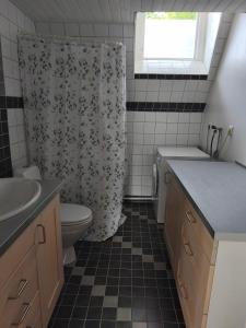a bathroom with a toilet and a shower curtain at The Colored Butterfly in Månstad +29 photos