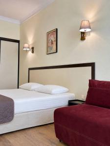 a hotel room with a bed and a couch at Corona Hotel & Apartments in Odesa