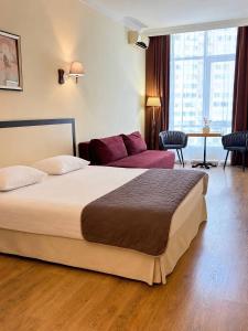 a hotel room with a bed and a couch at Corona Hotel & Apartments in Odesa