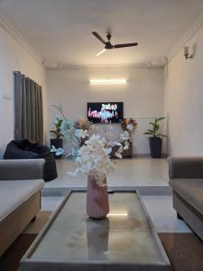 a living room with a vase of flowers on a table at Villa Grand Classic in Covelong