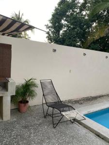 a black chair sitting next to a swimming pool at C12 · Casa 2 niveles, alberca y vista al manglar in La Peñita de Jaltemba