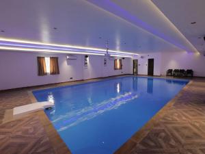 a large swimming pool in a building with blue lighting at Villa Grand Classic in Covelong
