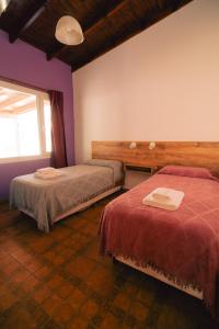 a bedroom with two beds and a window at Cabañas Entre Campos in Los Reartes