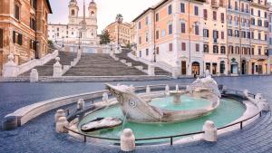 a fountain in the middle of a street with buildings at GG Spagna Luxury Suites in Rome