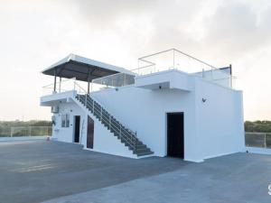 a white building with stairs on the side of it at Villa Grand Classic in Covelong
