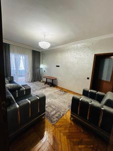 a living room with two leather couches and a table at Goris Central House in Goris