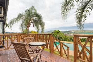 a deck with a table and chairs and a view of a pool at Ukholo Lodge in Citrusdal