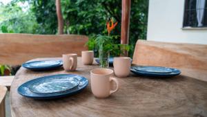 a wooden table with blue plates and mugs on it at El Cerrito in Puerto Jiménez