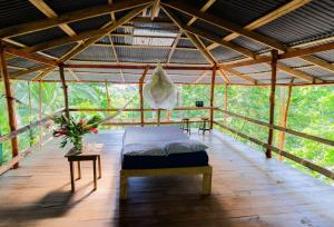 a room with a bed on a wooden floor at El Cerrito in Puerto Jiménez