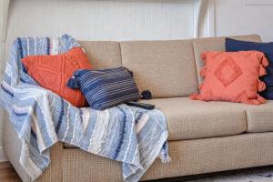 a couch with pillows and a blanket on it at Pet-Friendly Downtown Kanab Basecamp | Hot Tub in Kanab
