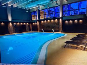 a large swimming pool in a building with chairs at Lenzo Apartments in Krakow