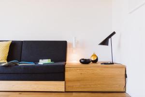 ein schwarzes Sofa mit einer Lampe auf einem Holztisch in der Unterkunft Haus Wieckin in Wieck