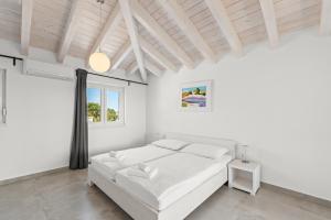 a white bedroom with a bed and a window at Villas Marisol in Premantura +70 photos