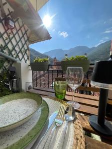 a table with two plates and wine glasses on a balcony at Le Grenier - Appartement vacances in Breil-sur-Roya
