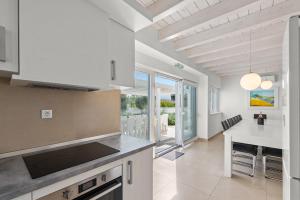 a kitchen with white appliances and a large window at Villas Marisol in Premantura