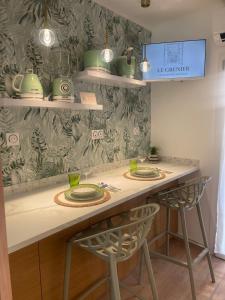 a kitchen with two chairs and a counter with green dishes at Le Grenier - Appartement vacances in Breil-sur-Roya