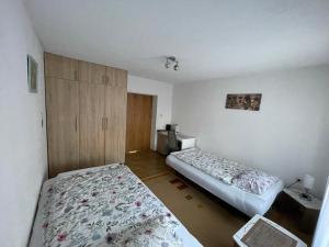 a bedroom with two beds and a cabinet in it at Restful Garden Apartmants in Sarajevo +46 photos