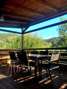 a table and chairs on a deck with a view at Green Yard Doftana in Teşila