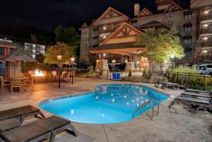 a swimming pool at night with tables and chairs at Bearskin Lodge on the River in Gatlinburg