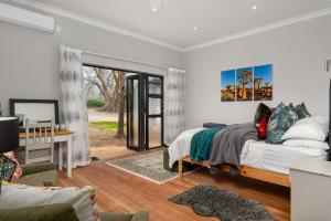 a bedroom with a bed and a desk and a window at Ukholo Lodge in Citrusdal +23 photos