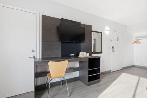 a desk with a television and a chair in a room at Motel 6-Washington, DC in Washington, D.C.