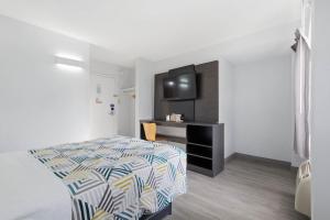 a bedroom with a bed and a tv in it at Motel 6-Washington, DC in Washington, D.C.