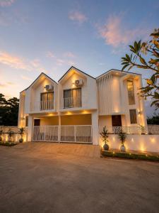 a large white house with a large driveway at Luxurious boho pool villa nandi hills in Bangalore