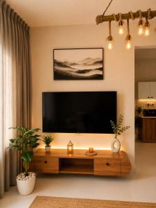 a living room with a large flat screen tv on the wall at Luxurious boho pool villa nandi hills in Bangalore