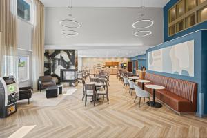 a rendering of a restaurant with tables and chairs at Home Inn & Suites Regina Airport in Regina